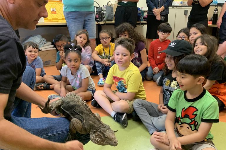 Reptile Handler Shows Children a lizard during Critter Kids Camp